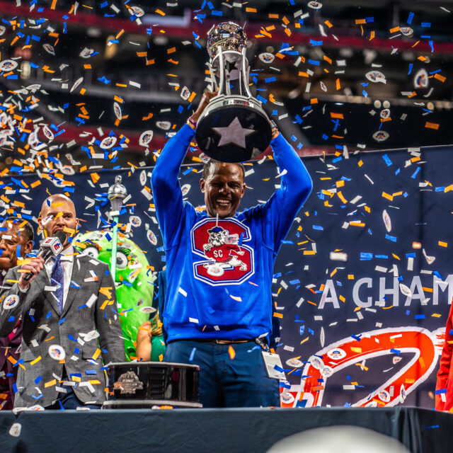 South Carolina State Head Coach Chennis Berry hoists the Criket Celebration Bowl Trophy.